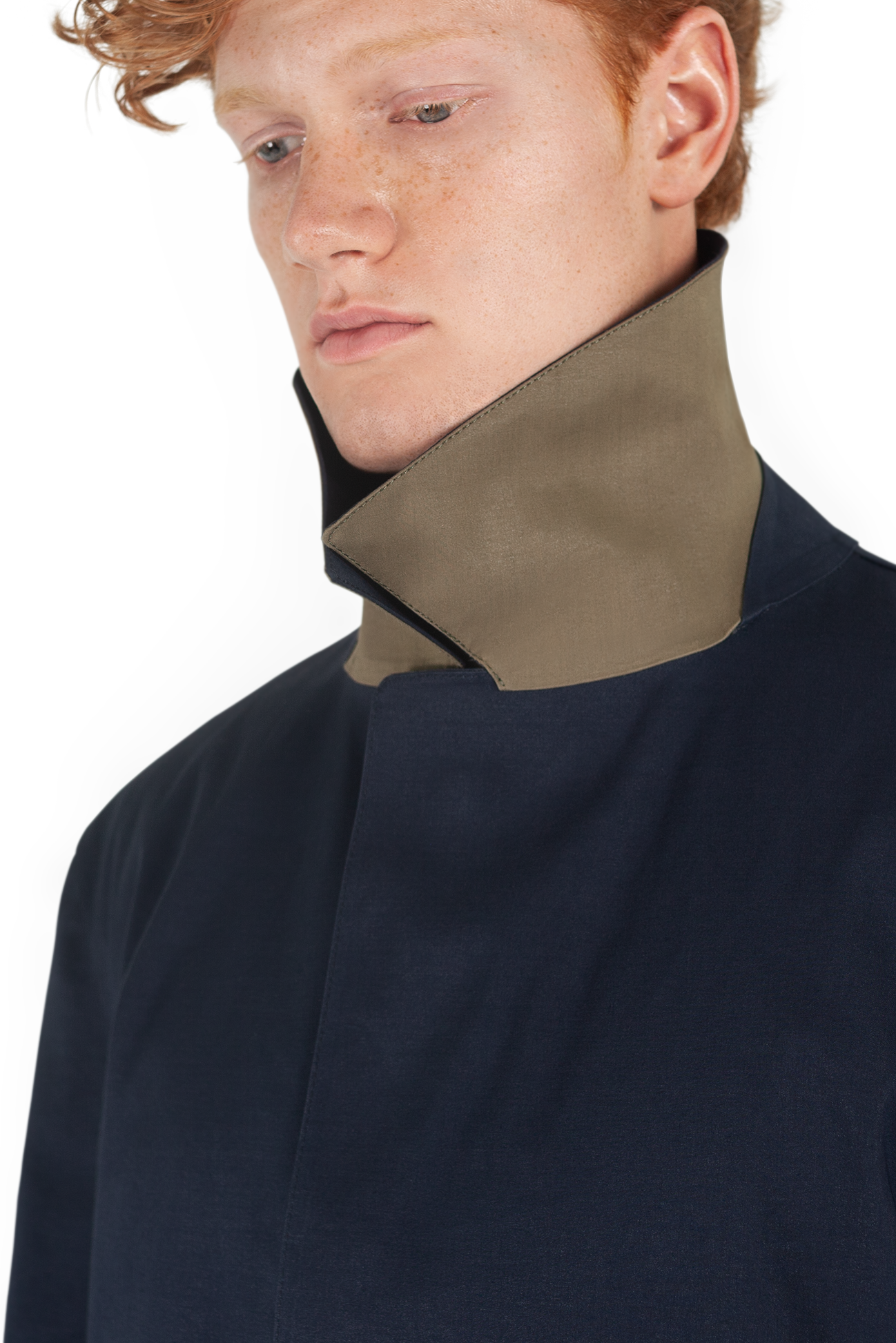 Close up shot of male ginger model wearing navy Faeroes mackintosh with collar up showing kelp contrast colour underside