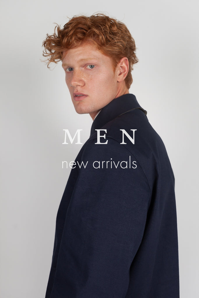 Male ginger model wearing contemporary navy coloured mackintosh from Faeroes new rainwear collection